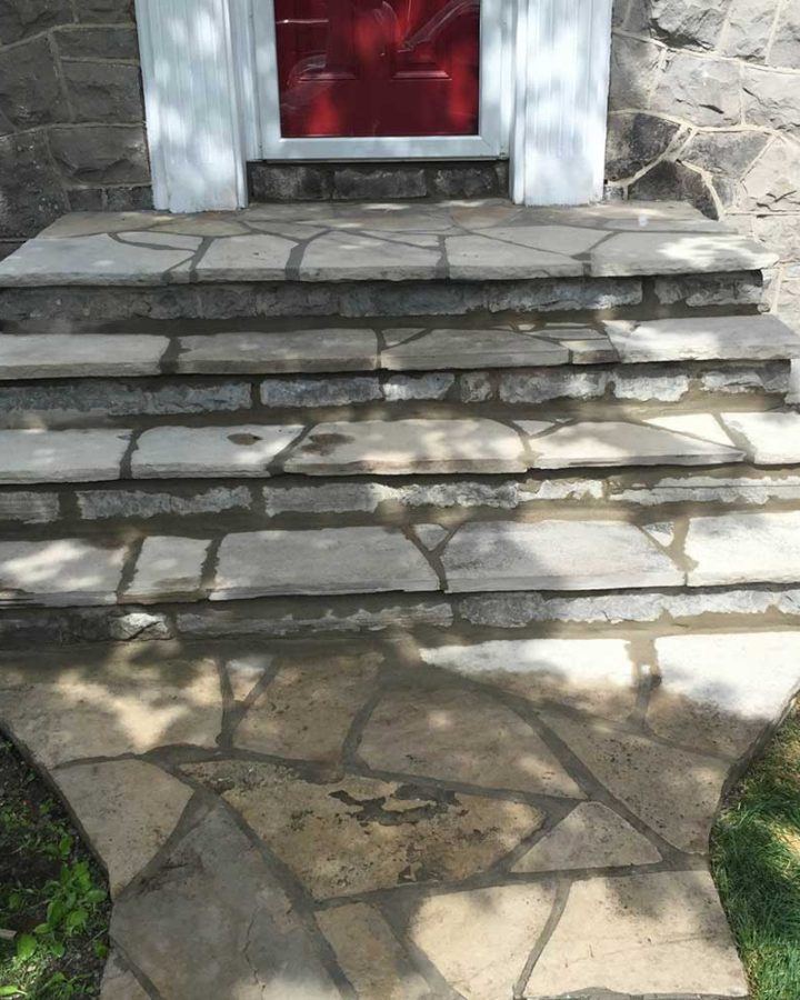 a set of stone steps leading to a red door