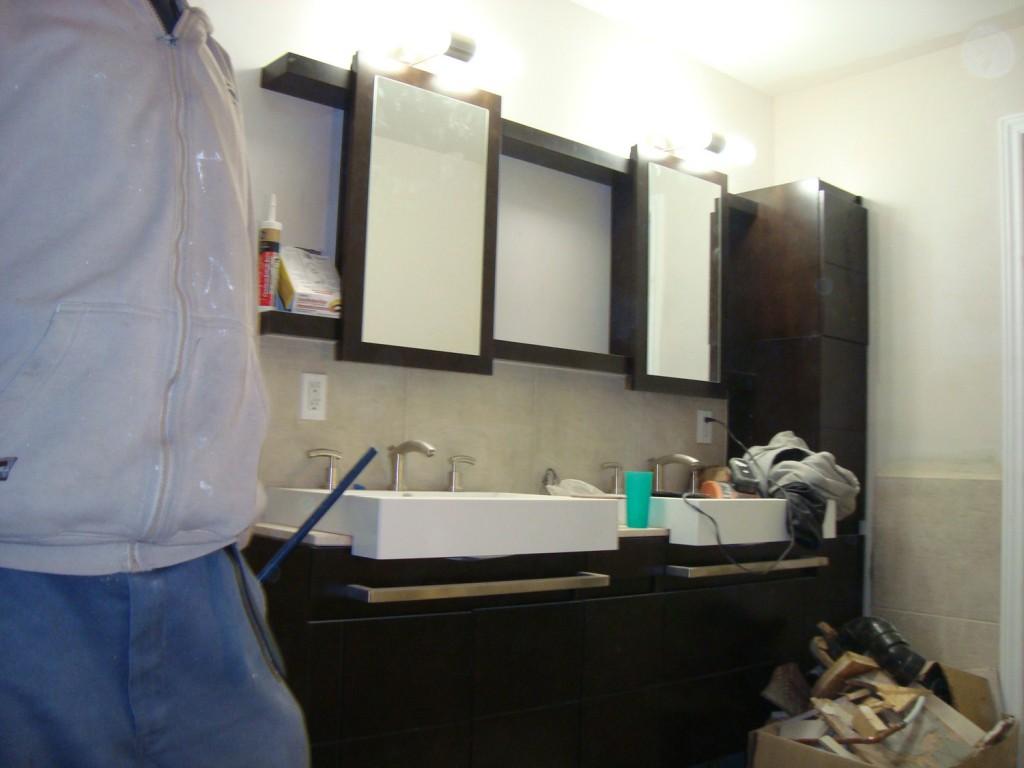 a man standing in front of a bathroom sink