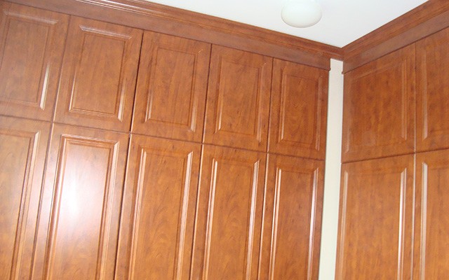 a corner of a kitchen with wooden cabinets