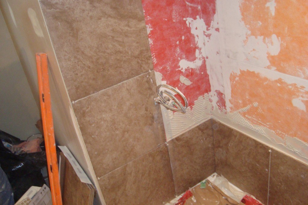 a bathroom that is being remodeled with red and orange paint